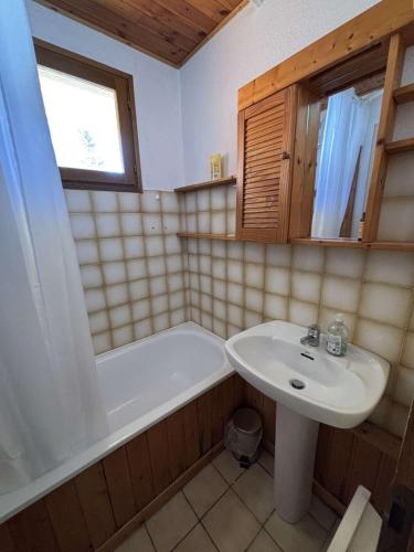 une salle de bain avec un lavabo et une baignoire et un lavabo dans l'établissement Yéti 6 n° 8 : appartement rénové au Petit Chatel, à Châtel