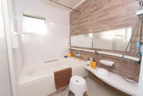 a white bathroom with a tub and a sink at KR family terrace in Tokyo