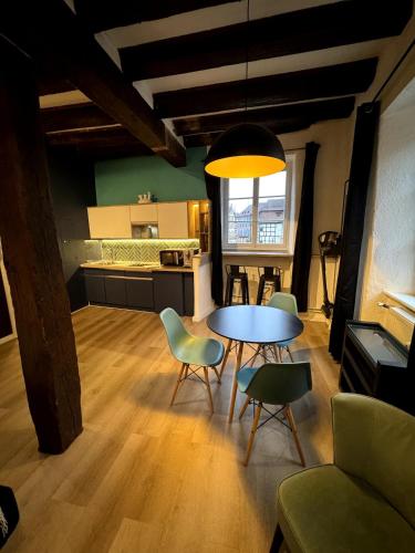 un salon avec une table et des chaises et une cuisine dans l'établissement Les Suites Schwendi en Hypercentre, à Colmar