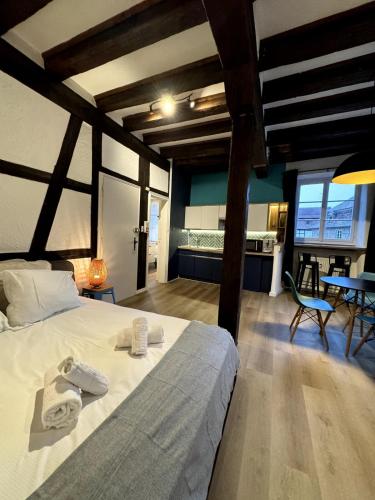 une chambre avec un lit, une table et des chaises dans l'établissement Les Suites Schwendi en Hypercentre, à Colmar