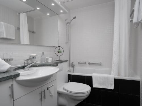 a bathroom with a sink and a toilet and a shower at Apartment Double Room Modern-11 by Interhome in Ascona
