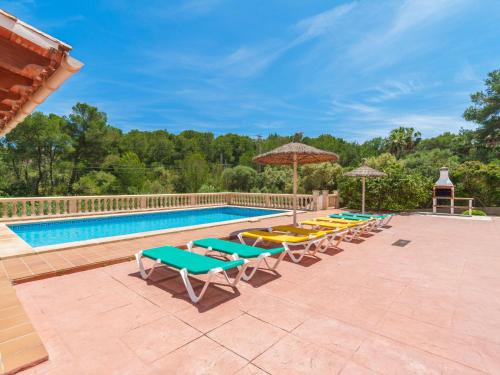 a pool with lounge chairs and umbrellas at Holiday Home Lisboa by Interhome in Cala Murada