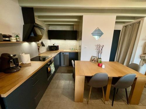 een keuken met een houten tafel en een eetkamer bij Le Donjon - Agréable T2 centre ville - parking gratuit 2 min - in Mont-de-Marsan