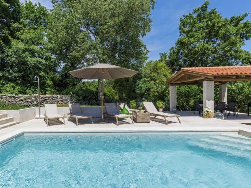 una piscina con sillas y sombrilla en Holiday Home Nino by Interhome, en Kršan