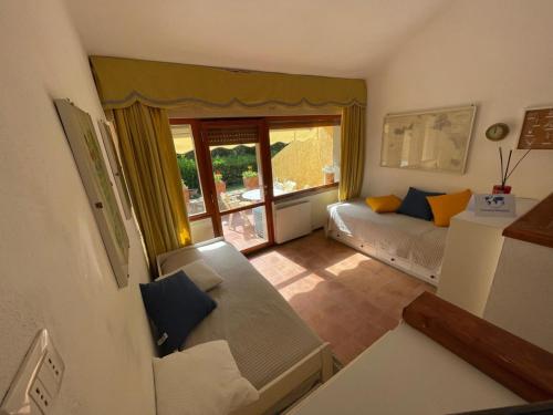 a small living room with a couch and a window at Appartamento tra Verde e Mare by Holiday World in Punta Ala