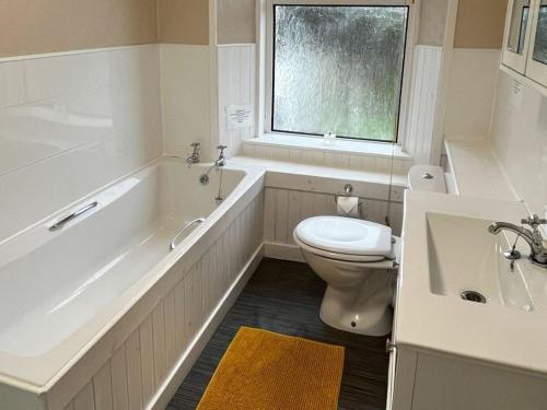 a bathroom with a tub and a toilet and a sink at Holiday Home Harlosh by Interhome in Roag