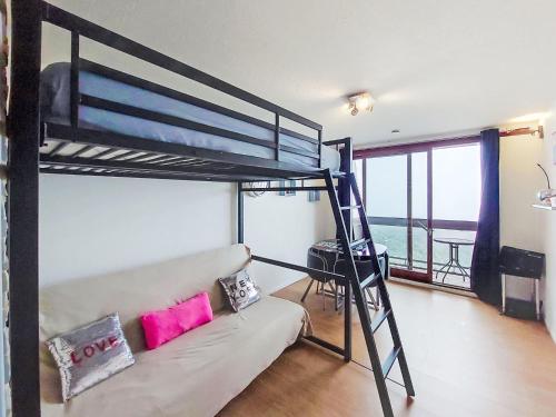 un soggiorno con letto a castello e divano di Studio Pegase Phenix-66 by Interhome a Le Corbier