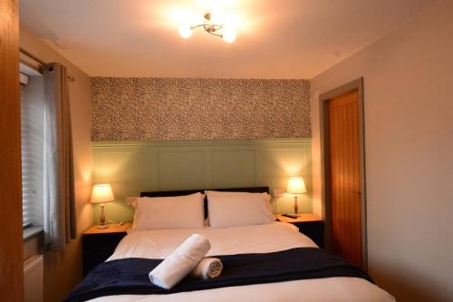 a bedroom with a bed with two pillows on it at Durham City Cottages in Durham