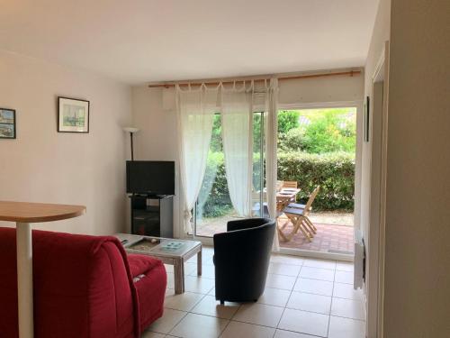 un salon avec un canapé rouge et une table dans l'établissement Apartment Océane by Interhome, à Arcachon