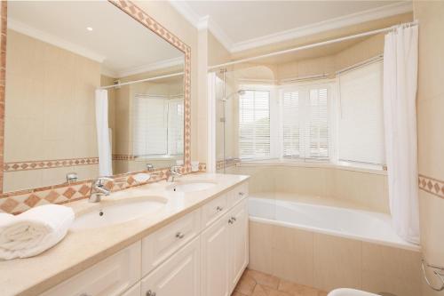 a bathroom with a tub and a sink and a bath tub at Vale Do Lobo Resort in Vale do Lobo
