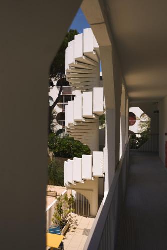 an external view of a building with white stairs at Hôtel Les Rives Bleues in La Grande-Motte