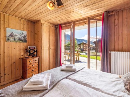 a bedroom with a large bed and a large window at Apartment Fury rez by Interhome in Verbier