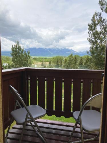two chairs on a deck with a view of mountains at Apartmán KaTry in Veľká Lomnica