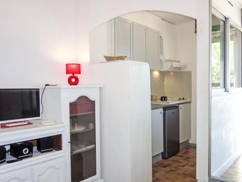 une cuisine avec des armoires blanches et une bougie rouge sur le dessus dans l'établissement Studio Le Liberté-8 by Interhome, à Saint Cyprien Plage