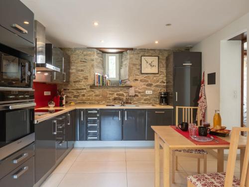 une cuisine avec des armoires noires et une table en bois dans l'établissement Apartment La Manoir du Moros by Interhome, à Concarneau