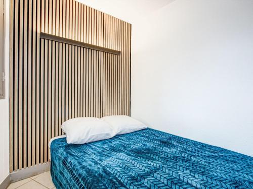 une chambre avec un lit avec une tête de lit en bois dans l'établissement Apartment Copacabana-32 by Interhome, à Canet