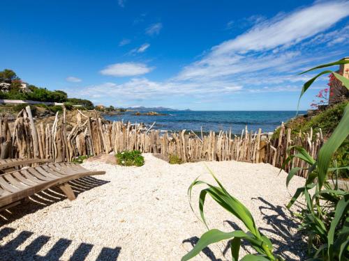 un banc sur une plage avec une clôture en bois dans l'établissement Holiday Home Zita by Interhome, à Saint-Aygulf