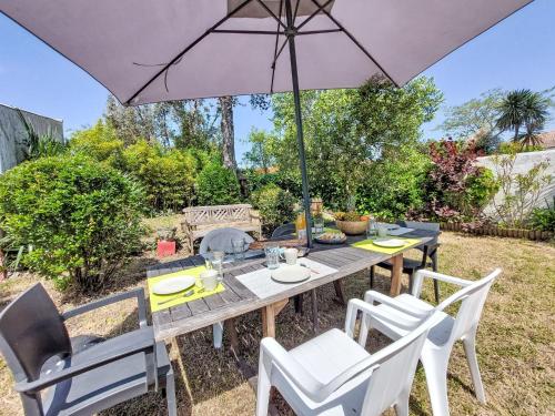 - une table et des chaises avec un parasol dans la cour dans l'établissement Holiday Home Villa Salut l'Artiste by Interhome, à Les Sables-dʼOlonne