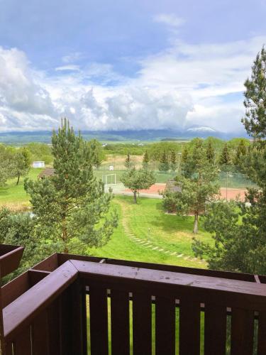 a balcony with a view of a yard with trees at Apartmán KaTry in Veľká Lomnica
