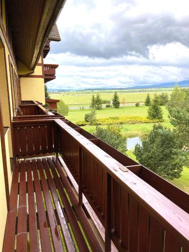 a balcony of a house with a view of a field at Apartmán KaTry in Veľká Lomnica