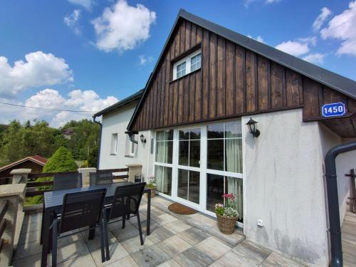 a wooden building with a table and chairs on a patio at Holiday Home U sjezdovky by Interhome in Smržovka