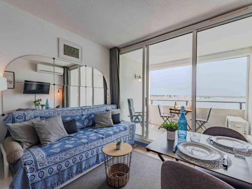 un salon avec un canapé bleu et une table dans l'établissement Apartment Les Marquises-8 by Interhome, au Barcarès