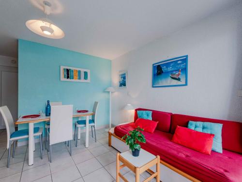 un salon avec un canapé rouge et une table dans l'établissement Apartment Antigua-12 by Interhome, au Barcarès
