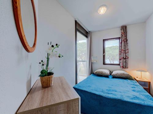 une chambre avec un lit bleu et un miroir dans l'établissement Apartment Antigua-12 by Interhome, au Barcarès