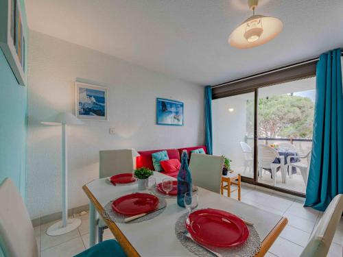 d'une salle à manger avec une table et des assiettes rouges. dans l'établissement Apartment Antigua-12 by Interhome, au Barcarès