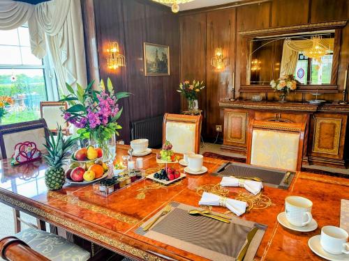 a dining room with a table with fruit on it at FINN VILLAGE Loch Lomond Villa - THE BLACK ROOM with Private Jacuzzi-Style Bath in Drymen