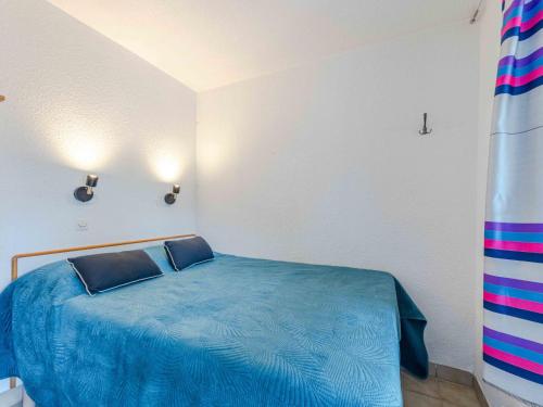 - une chambre avec un lit bleu et 2 oreillers dans l'établissement Apartment Caraibes-4 by Interhome, au Barcarès