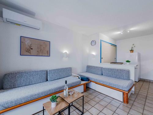 un salon avec deux canapés bleus et une table dans l'établissement Apartment Caraibes-4 by Interhome, au Barcarès