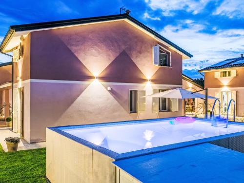 チェチナにあるHoliday Home Borgo il Vallin delle Conche-2 by Interhomeの家の前にホットタブ付きの裏庭プールがあります。