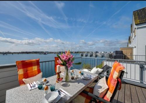 una mesa en un balcón con vistas al agua en Ferienwohnung Admiral Suite, en Kappeln