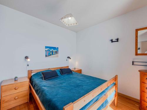 - une chambre avec un lit en bois et une couverture bleue dans l'établissement Apartment Antigua-7 by Interhome, au Barcarès