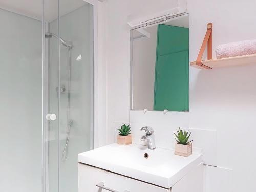 une salle de bain blanche avec un lavabo et un miroir dans l'établissement Apartment Le Mascoïnat by Interhome, à Nice