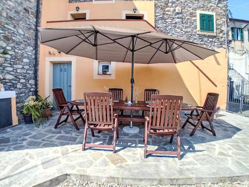 Una mesa con sillas y una sombrilla en un patio. en Apartment Giulia by Interhome, en Imperia