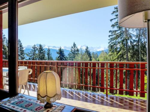 a room with a balcony with a view of the mountains at Apartment Les Faverges 5 by Interhome in Crans-Montana