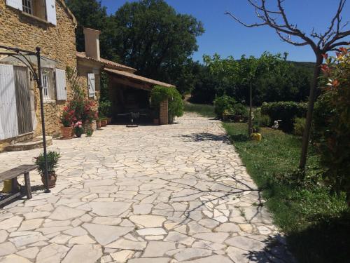un chemin de pierre devant une maison avec un bâtiment dans l'établissement Maison de caractère, à Saint-Montan