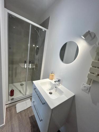 une salle de bain blanche avec un lavabo et une douche dans l'établissement Studio Centre-ville, à Libourne