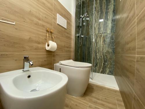 a bathroom with a sink and a toilet and a shower at Isid'Oro Rooms - 100m from the sea in Sant'Isidoro