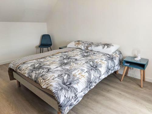 a bedroom with a bed and a chair and a table at Holiday Home La Trélennoise by Interhome in Plonéour-Lanvern