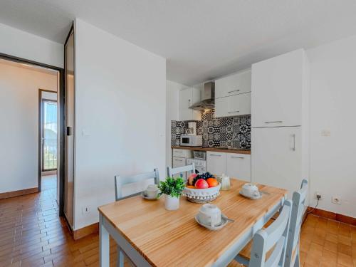 une cuisine et une salle à manger avec une table et des chaises en bois dans l'établissement Apartment Antigua-5 by Interhome, au Barcarès