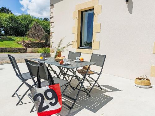 a table and chairs on the patio of a house at Holiday Home La Trélennoise by Interhome in Plonéour-Lanvern