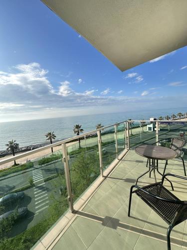 a balcony with a table and chairs and the ocean at Aqua Batumi 42 in Batumi