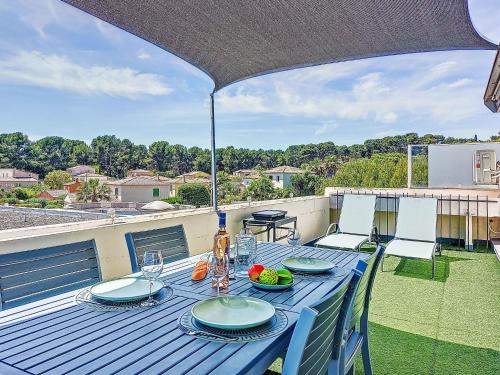 une table bleue et des chaises sur un balcon avec une table et des chaises dans l'établissement Apartment Le Fidji-2 by Interhome, à La Ciotat