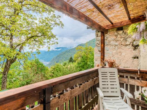 a white chair sitting on a wooden balcony with a view at Chalet Baita Ballardini by Interhome in Ragoli