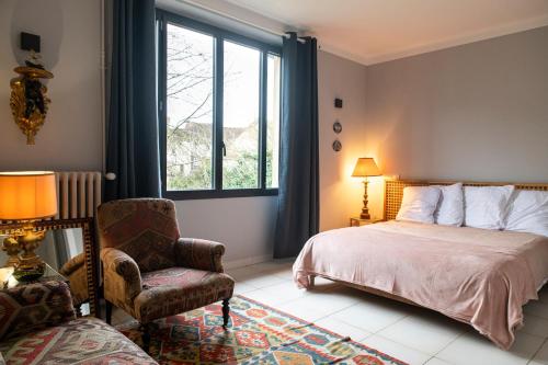 une chambre avec un lit, une chaise et une fenêtre dans l'établissement Le Picardeau Gîtes - Nature et Detente, à Nemours