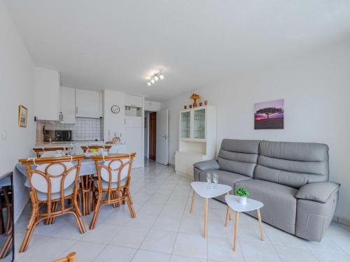 un salon avec un canapé, une table et des chaises dans l'établissement Apartment Antigua-4 by Interhome, au Barcarès