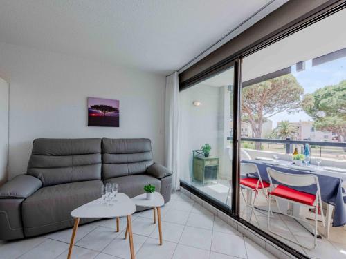 un salon avec un canapé, une table et des chaises dans l'établissement Apartment Antigua-4 by Interhome, au Barcarès